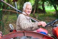 A senior man driving an old tractor in the forest Royalty Free Stock Photo