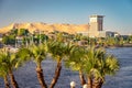 Aswan, Egypt - Movenpick hotel building on the bank of Nile river with palms in the foreground