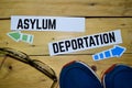 Asylum or Deportation opposite direction signs with sneakers and eyeglasses on wooden