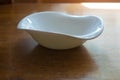 Asymmetric porcelain bowl on wooden table Royalty Free Stock Photo