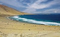 Atacama desert meets water: Beautiful secluded cove with deserted sandy beach on lonely wild uninhabited pacific coastline, blue Royalty Free Stock Photo