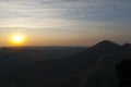 Atardecer entre montaÃ±as, cielo azul y nubes, sol brillante Royalty Free Stock Photo