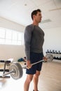 athelte looking away while lifting barbell at gym Royalty Free Stock Photo