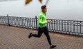 Athelte man running in the morning on the fog lake background. Runner male jogging in the park and listenting the music on Royalty Free Stock Photo