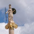Athena marble statue the ancient Greek goddess of knowledge and wisdom under a blue sky with clouds, some space for text.