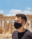 Athens Acropolis, Greece coronavirus days. Young man wearing protective face mask on Parthenon temple and blue sky background Royalty Free Stock Photo