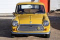 Front view of a yellow vintage Mini car.