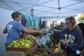 A vendor rings up a purchase of freshly harvested seasonal produce at an open air market.