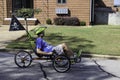 A man rides a recumbent tricycle on a street in Athens Georgia.
