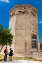 Young couple of tourists visiting the Tower of the Winds or the Horologion of Andronikos Kyrrhestes Royalty Free Stock Photo