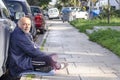 Athens, Greece / December 17,2018 Beggar asks for alms on the streets of Athens along the road cluttered with cars