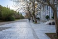 Athens / Greece Dionysiou Areopagitou street under acropolis hill. Winter bare trees and pedestrians on paved road