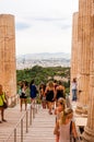 Tourists walking between the columns of ancient Propylaea, principal entryway to the Acropolis, built c. 432 BCE, with white