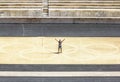 A man stands with his arms outstretched against the Olympic rings on the field of Panathenaic stadium in Athens Royalty Free Stock Photo