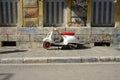 A red and white scooter parked in front of a building with graffiti Royalty Free Stock Photo