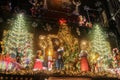 Ornate lit up Christmas display at night above Little Kooks store downtown with trees and carolers Royalty Free Stock Photo