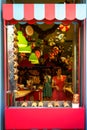 Colorful fairy tales theme shopfront decoration of sweet candies shop with beautiful young lady sellers in pink and blue dress Royalty Free Stock Photo