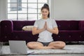 Athlete Asian indian woman looking laptop practice yoga lotus pose online course at home