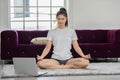 Athlete Asian indian woman looking laptop practice yoga lotus pose online course at home