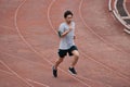 Athlete Asian man running on racetrack in stadium . Healthy active lifestyle concept.