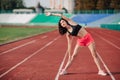 Athlete Attractive sporty brunette woman in pink shorts and top exercise stretching at sport stadium in evening, sunset. Sport and Royalty Free Stock Photo