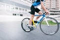 Athlete bicyclist rides against the backdrop of urban architecture. Man on a bright bike. Royalty Free Stock Photo