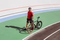 Athlete with a black bicycle at velodrome