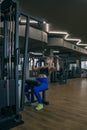 Athlete blond woman in the gym doing vertical thrust. Exercise for muscles of the back. Pulldown