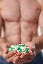 Athlete bodybuilder takes dope in the form of tablets form of pharma rapid progress in muscle Royalty Free Stock Photo