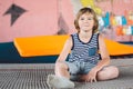 Athlete Caucasian boy sitting on trampoline after training. child is engaged in trampolining on professional trampoline outside. Royalty Free Stock Photo