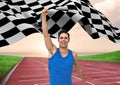 Athlete celebrating her victory with checkered flag on race track Royalty Free Stock Photo