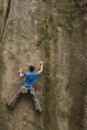 Athlete climbs on rock with rope.