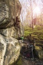 Athlete climbs on rock with rope.