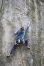 Athlete climbs on rock with rope.