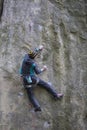 Athlete climbs on rock with rope.