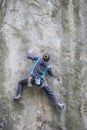 Athlete climbs on rock with rope.