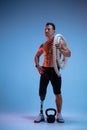 Athlete with disabilities or amputee on blue studio background. Professional male sportsman with leg prosthesis