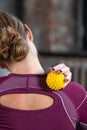 The athlete does a relaxing massage of the neck and back with the help of a prickly rubber ball. Royalty Free Stock Photo