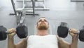 Athlete doing exercise for chest with dumbbells. young muscular man trains at the gym. Royalty Free Stock Photo