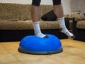 Athlete doing strength and balance exercises on a bosu ball at home Royalty Free Stock Photo