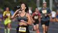 Athlete drink water bottle. Thirsty person run. Woman runner jog sport marathon.