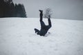 Athlete falls from a plastic snowboard and falls hard on the snow and sprawls. The boy`s board got stuck and it threw him out and