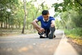 Athlete fit Asian man stretching his legs on the street, warming up before running Royalty Free Stock Photo