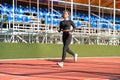 Athlete fitness woman runner jogging exercise on stadium on sunny summer day. Sporty training cardio for weight loss success Royalty Free Stock Photo