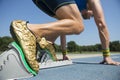 Athlete in Gold Shoes on Starting Blocks Royalty Free Stock Photo