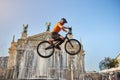 Athlete in helmet performing stunt in front of a fountain.
