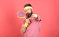 Athlete hipster hold tennis racket in hand red background. Tennis sport and entertainment. Man bearded hipster wear Royalty Free Stock Photo