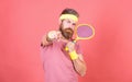 Athlete hipster hold tennis racket in hand red background. Tennis sport and entertainment. Man bearded hipster wear Royalty Free Stock Photo