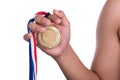 Athlete holding gold medal with ribbon on his hand Royalty Free Stock Photo