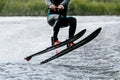 athlete jump waterskiing behind motor boat on lake